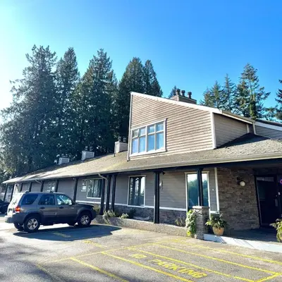 a car parked in a parking lot in front of a building at Sunshine Lodge Inn in Gibsons