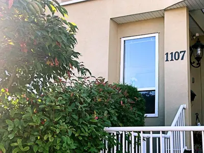 a house with a bush in front of a window at Star of the Sea guest house in White Rock