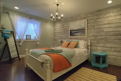 a bedroom with a bed and a wooden wall at Shawnigan Suite B & B in Shawnigan Lake