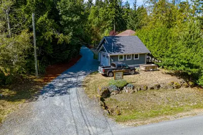 a small house with a truck parked in front of it at Shawnigan Suite B & B in Shawnigan Lake