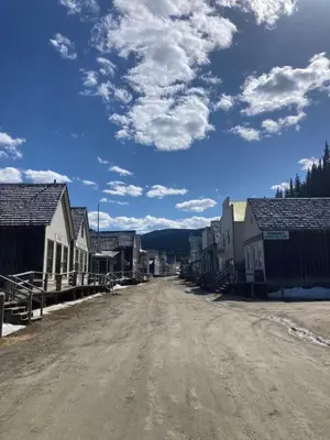 an empty dirt road in a village with houses at St. George Hotel in Barkerville