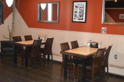 a dining room with wooden tables and chairs at Canadas Best Value Inn- Riverview Hotel in Whitehorse