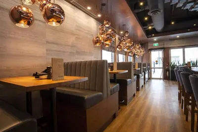 a dining room with chairs and tables in a restaurant at Sandman Signature Sherwood Park Hotel in Sherwood Park