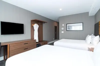 a hotel room with two beds and a flat screen tv at Sandman Signature Sherwood Park Hotel in Sherwood Park