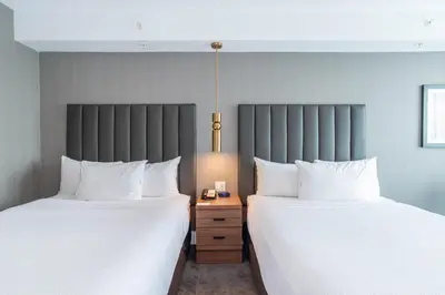 two beds sitting next to each other in a room at Sandman Signature Sherwood Park Hotel in Sherwood Park