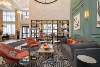 a living room with a couch and chairs and a table at Sandman Signature Sherwood Park Hotel in Sherwood Park