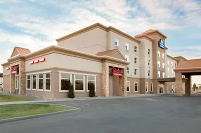 a hotel with a sign on the front of it at Days Inn & Suites by Wyndham Edmonton Airport in Leduc
