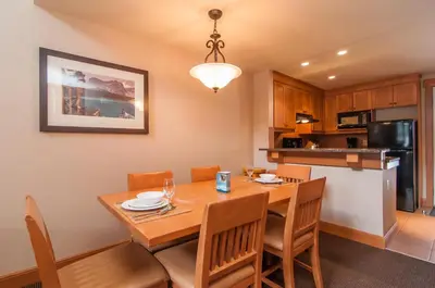 a kitchen and dining room with a wooden table and chairs at The Hidden Ridge Resort in Banff