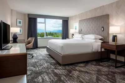 a hotel room with a bed and a desk and a television at Sheraton Vancouver Guildford Hotel in Surrey