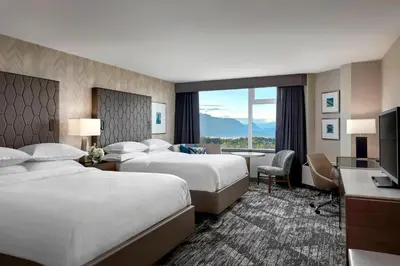 a hotel room with two beds and a television at Sheraton Vancouver Guildford Hotel in Surrey