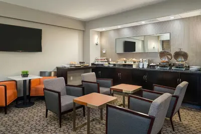 a restaurant with a bar with chairs and tables at Sheraton Vancouver Guildford Hotel in Surrey