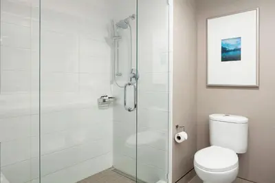 a bathroom with a toilet and a glass shower at Sheraton Vancouver Guildford Hotel in Surrey