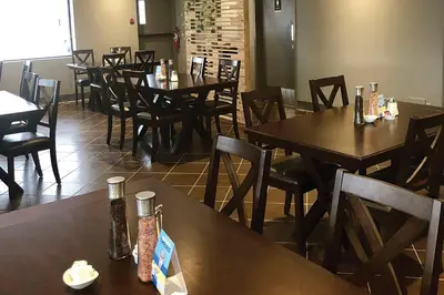 a dining room with wooden tables and chairs at Comfort Inn West in Edmonton