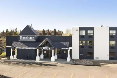a building with a sign for a hotel at Travelodge by Wyndham Edmonton South in Edmonton