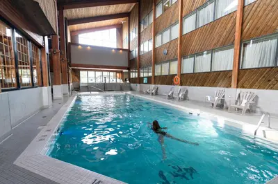 a woman swimming in a pool in a building at Lake Louise Inn in Lake Louise