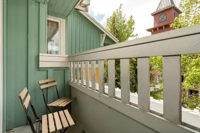 a porch with a bench and a clock tower at Bear Lodge (Town Plaza) in Whistler