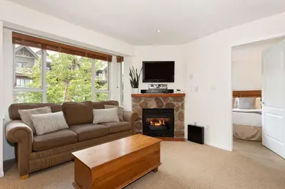 a living room with a couch and a fireplace at Bear Lodge (Town Plaza) in Whistler