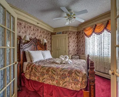 a bedroom with a bed and a ceiling fan at Athabasca Hotel in Jasper