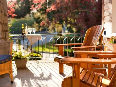 a patio with two chairs and a table with wine glasses at Abbeymoore Manor in Victoria