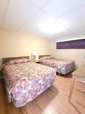 a hotel room with two beds and a table at Shannon Motel in Fort Nelson
