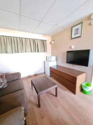 a living room with a couch and a flat screen tv at Shannon Motel in Fort Nelson