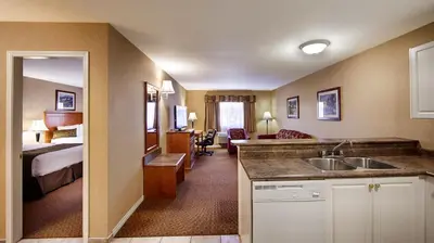 a hotel room with a sink and a bedroom at Best Western Plus Osoyoos Hotel & Suites in Osoyoos