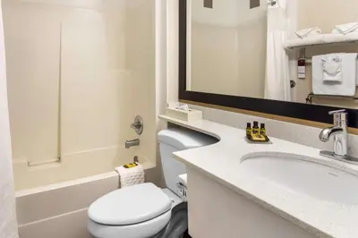 a bathroom with a toilet and a sink and a mirror at Best Western Plus Osoyoos Hotel & Suites in Osoyoos