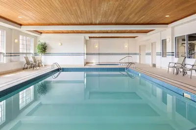 an indoor pool with a wooden ceiling and a swimming poolvisor at Country Inn & Suites by Radisson, Calgary-Northeast in Calgary