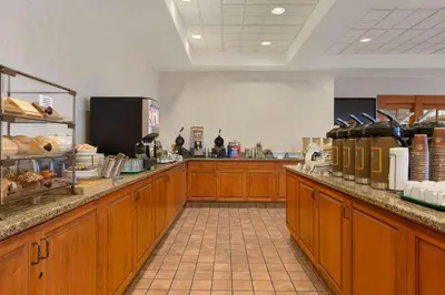 a kitchen with wooden cabinets and a counter with food at Country Inn & Suites by Radisson, Calgary-Northeast in Calgary