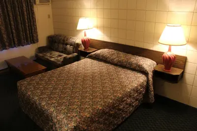 a hotel room with a bed and two lamps at Best Continental Motel in Hope