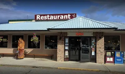 a restaurant with a woman standing outside of it at Best Continental Motel in Hope