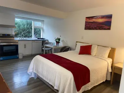 a bedroom with a large bed and a kitchen at Slumber Lodge in Hope