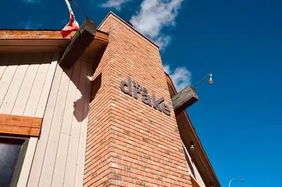 a brick building with a clock on the side of it at The Drake Inn in Canmore