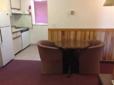 a small kitchen with a table and two chairs at Rainbow Motor Inn in Chilliwack