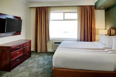 a hotel room with a bed and a television at Chateau Nova Yellowhead in Edmonton