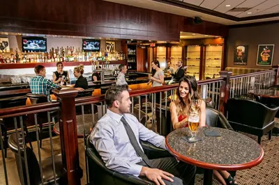 a man and woman sitting at a table in a bar at Chateau Nova Yellowhead in Edmonton