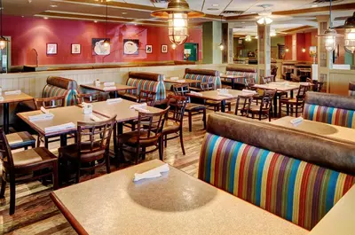 a restaurant with tables and chairs and a bar at Chateau Nova Kingsway in Edmonton