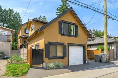 a yellow house with a white garage at Minimal - 90 nights min in Vancouver