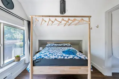 a bedroom with a bed with a wooden bed frame at Minimal - 90 nights min in Vancouver
