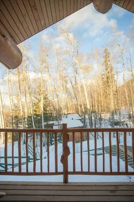 a porch with a view of trees in the snow at Williston Lake Resort in Hudson Hope