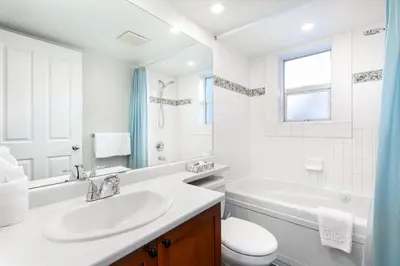 a white bathroom with a sink and a tub and a toilet at Glaciers Reach by Allseason Vacation Rentals in Whistler