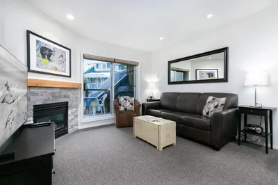 a living room with a couch and a fireplace at Glaciers Reach by Allseason Vacation Rentals in Whistler