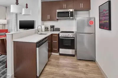 a kitchen with stainless steel appliances and wooden cabinets at TownePlace Suites by Marriott Edmonton Sherwood Park in Sherwood Park