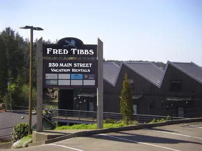 a sign in a parking lot in front of a building at Island Village Properties at Fred Tibbs in Tofino