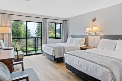 a hotel room with two beds and a window at Tofino Motel Harbourview in Tofino