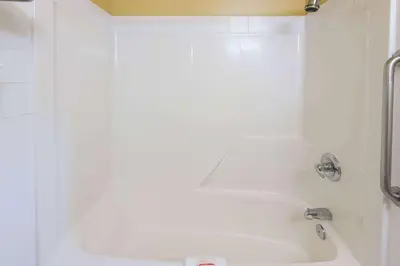 a white bathroom with a tub and a sink at Super 8 by Wyndham Cochrane in Cochrane