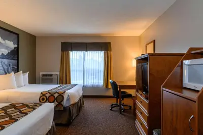 a hotel room with two beds and a television at Super 8 by Wyndham Cochrane in Cochrane