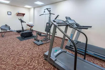 a gym with several tread machines in a room at Super 8 by Wyndham Cochrane in Cochrane