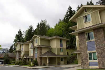 a row of apartment buildings with trees in the background at Vancouver Island Residences in Nanaimo