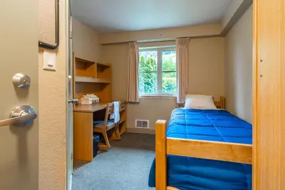 a bedroom with a bed and a desk and a window at Vancouver Island Residences in Nanaimo